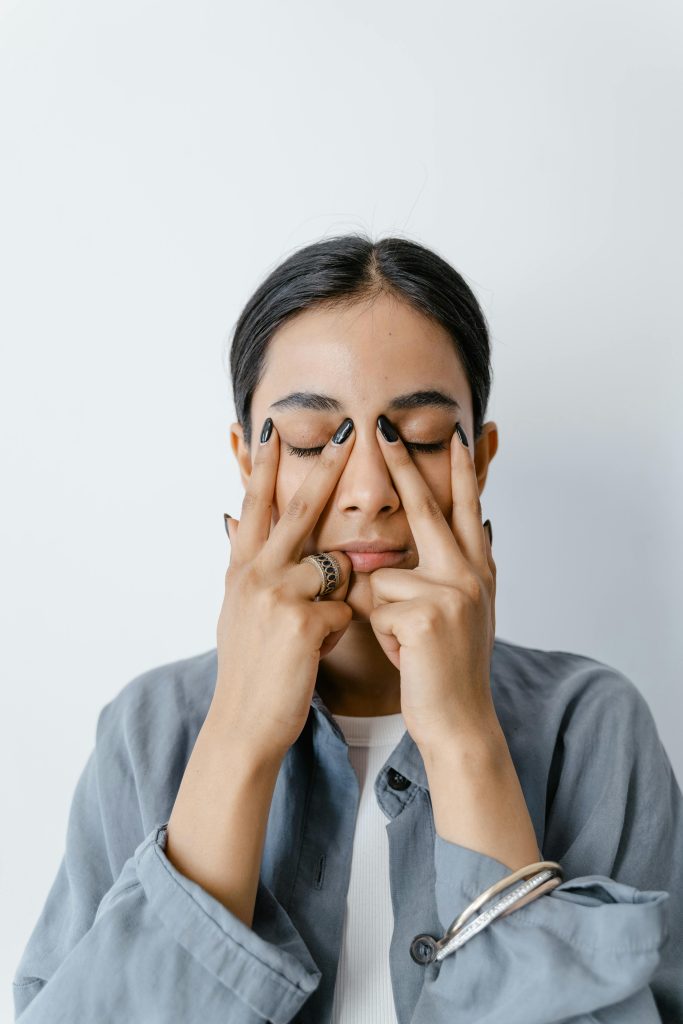 Young woman practicing eye area facial yoga from Dr. Pat Boulogne’s anti aging facial treatment techniqu