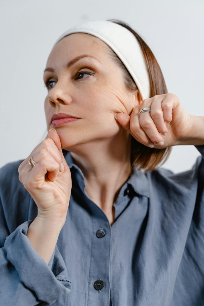 Woman checking facial skin elasticity as part of anti aging facial treatment for wrinkle prevention and youthful skin.