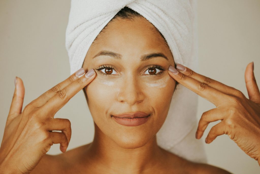 Woman applying eye cream as part of anti aging facial treatment for glowing, youthful skin and wrinkle care.