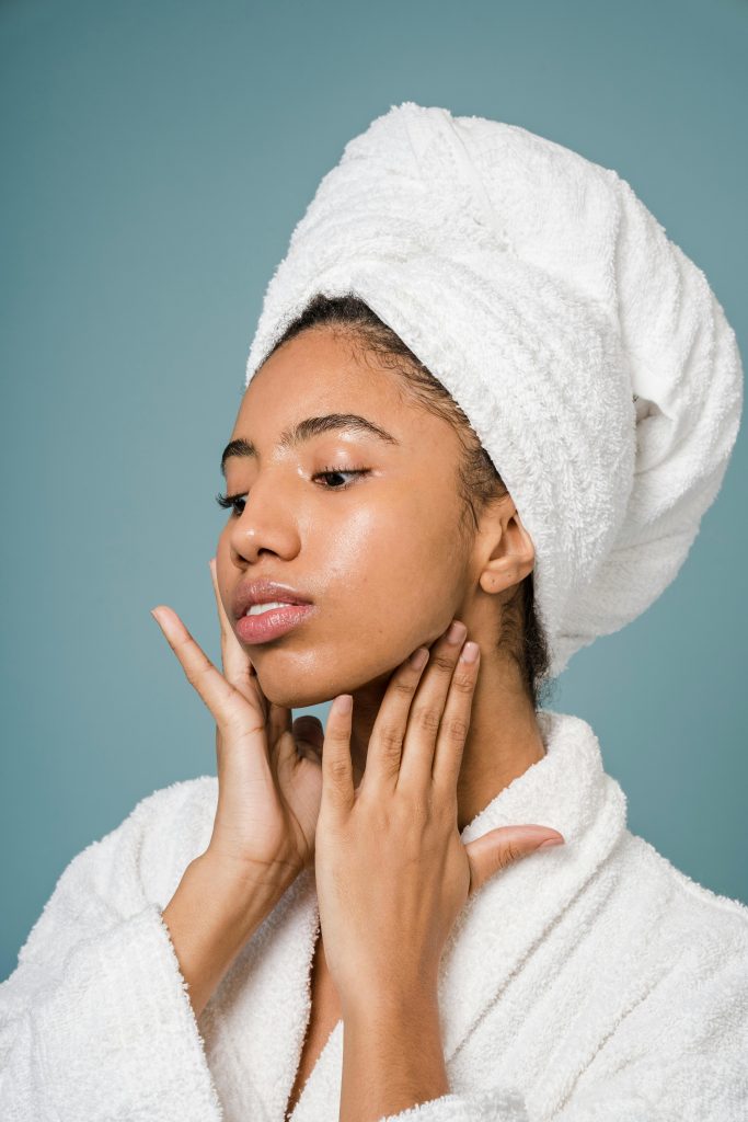 Woman massaging her jawline as part of Dr. Pat Boulogne’s anti aging facial treatment routine.