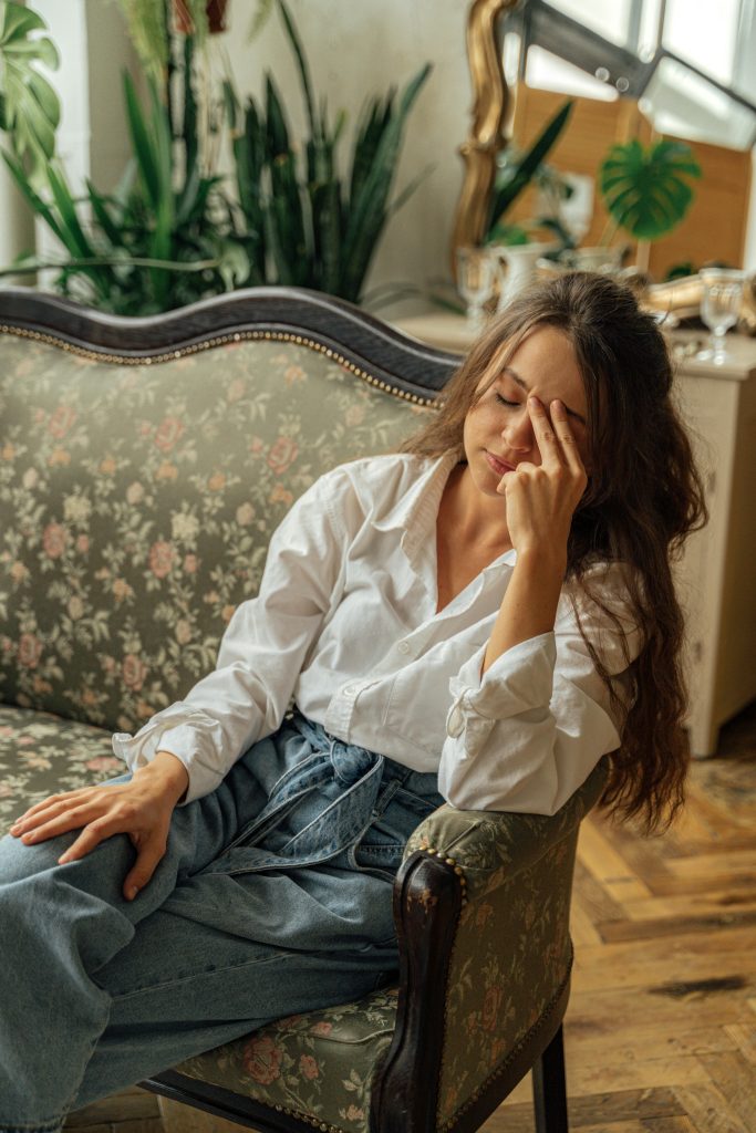 Exhausted entrepreneur on a couch, reflecting burnout—Dr. Pat Boulogne , a lifestyle coach, helps through lifestyle coaching solutions.